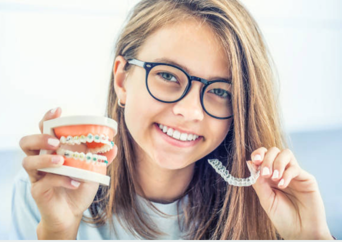 Image of a woman holding her orthodontic / Invisalign trays Image of a woman holding her orthodontic / Invisalign trays